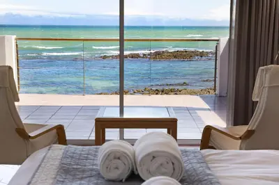 a hotel room with a view of the ocean at Villa Kyma in Gordonʼs Bay