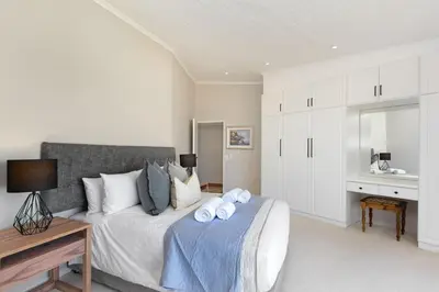 a bedroom with a bed with two towels on it at Villa Kyma in Gordonʼs Bay