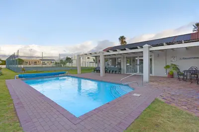 a swimming pool in the yard of a house at Villa Kyma in Gordonʼs Bay