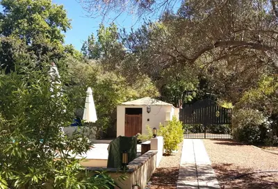 a backyard with a fence and a table and a umbrella at Gästehaus HelderbergView in Somerset West