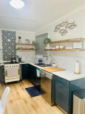 a kitchen with blue cabinets and a sink at Adorable 2 Bedroom Cottage with spacious veranda in Hermanus