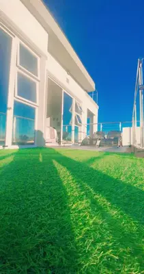a large white house with a green lawn at Kwaaami in Cape Town