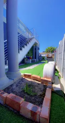 a building with a staircase and a grass yard at Kwaaami in Cape Town
