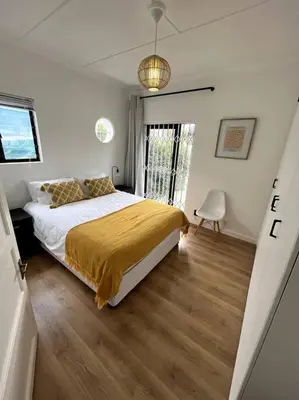 a bedroom with a bed with a yellow blanket on it at Centrally located modern 2-bedroom home & parking in Cape Town