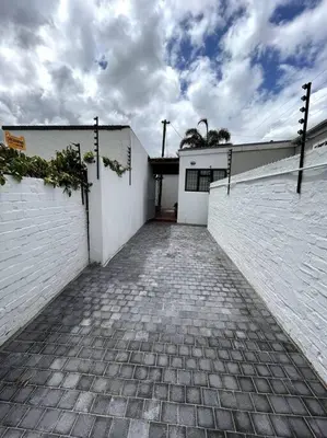 a white building with a brick walkway in front at Centrally located modern 2-bedroom home & parking in Cape Town