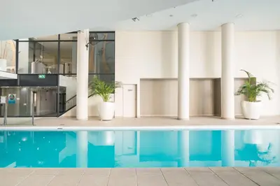 a swimming pool in a building with potted plants at Knightsbridge 108 in Cape Town