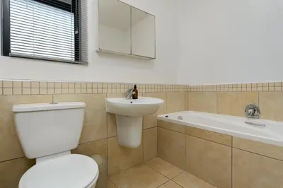 a bathroom with a toilet and a sink and a tub at Knightsbridge 108 in Cape Town