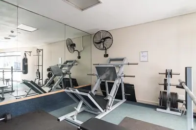 a gym with several tread machines and a mirror at Knightsbridge 108 in Cape Town