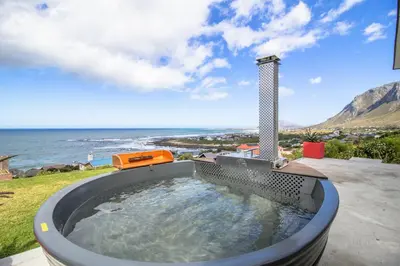 a hot tub with a view of the ocean at Jock's View in Bettyʼs Bay