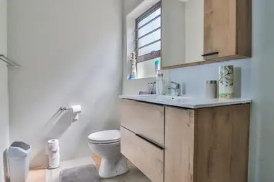 a bathroom with a toilet and a sink and a window at Jock's View in Bettyʼs Bay