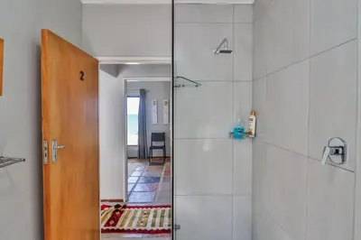 a bathroom with a shower with a glass door at Jock's View in Bettyʼs Bay