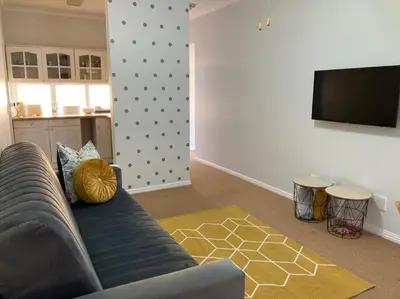 a living room with a couch and a flat screen tv at Johan-nest in Cape Town