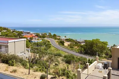 a view of a road and the ocean at Atlantic Sky Villa in Gordonʼs Bay