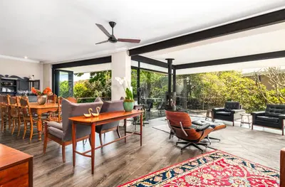 a dining room and living room with a ceiling fan at Luxury Stellenbosch Villa in Stellenbosch