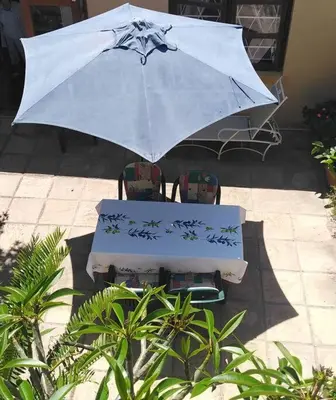 a table with an umbrella and two chairs and a table with at The Wee Hoose in Strand