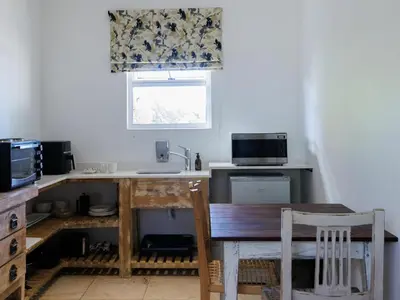 a kitchen with a table and a sink and a window at Dawn Mountains Farm in Simondium