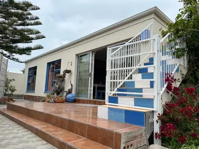 a house with blue and white stairs in front at Coastal House: 3BR+Private Entrance+Self catering in Cape Town