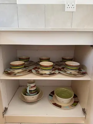 a white shelf with plates and bowls on it at Coastal House: 3BR+Private Entrance+Self catering in Cape Town