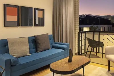 a living room with a blue couch and a table at Bridgewater View 415 in Cape Town