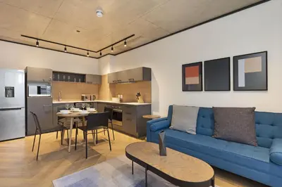 a living room with a blue couch and a kitchen at Bridgewater View 415 in Cape Town