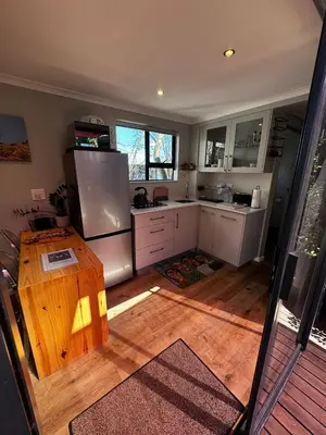 a kitchen with a refrigerator and a wooden floor at The Leopard Leaf Inn in Cape Town