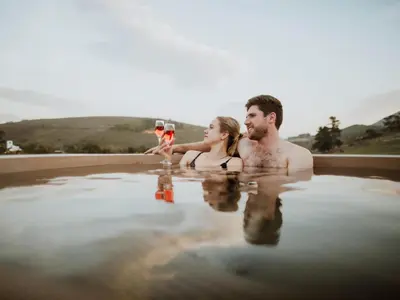 a man and a woman sitting in a pool of water at Ou Meul Farm Cottage in Botrivier