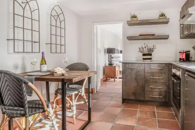a kitchen with a wooden table and chairs at Avemore Rare Gem with full Backup Power in Stellenbosch