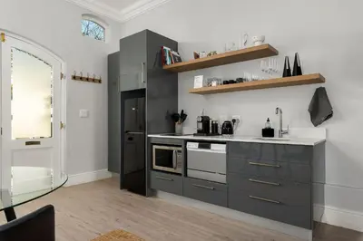 a kitchen with gray cabinets and a stove top oven at Luxury Winetram getaway in Franschhoek