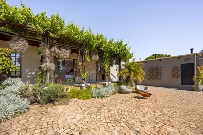 a house with a brick courtyard with plants at Avemore Time Out - full power back up in Stellenbosch