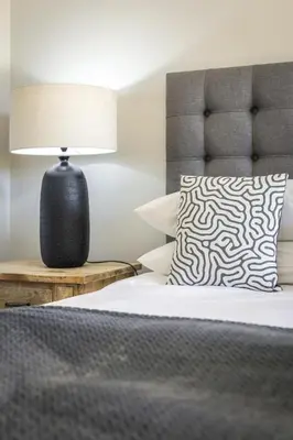 a bedroom with a bed with a pillow and a lamp at Avemore Time Out - full power back up in Stellenbosch