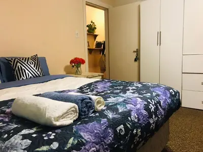 a bedroom with a bed with a blanket on it at LRN Brackenfell Homestay in Cape Town