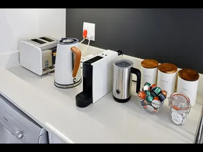 a kitchen counter with a coffee maker and a toaster at The Village Cottage in Franschhoek