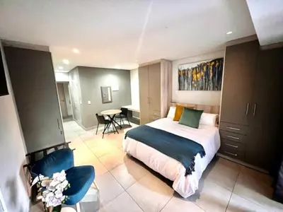 a bedroom with a bed and a table and chairs at Modern Apartment in Stellenbosch in Stellenbosch
