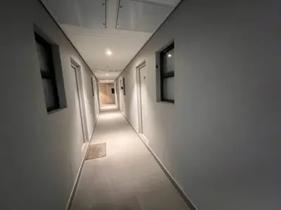 a hallway with white walls and a long hallway with doors at Modern Apartment in Stellenbosch in Stellenbosch