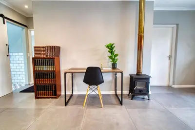 a table and a chair in a room with a stove at Magnificent Villa Load-Shedding Free! in Cape Town