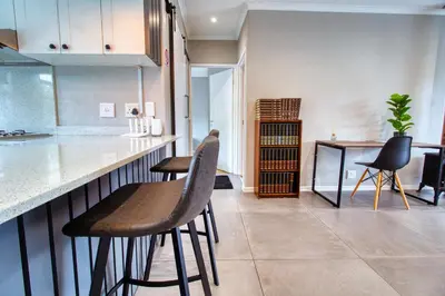 a kitchen with two stools at a counter at Magnificent Villa Load-Shedding Free! in Cape Town