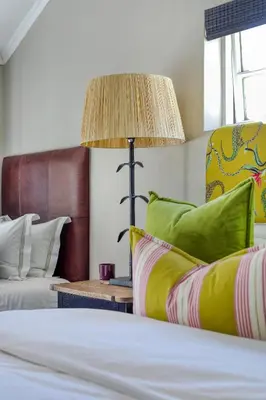 a bedroom with a bed and a table with a lamp at Loft de L'Opera - Franschhoek in Franschhoek