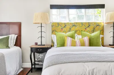 a bedroom with a bed with green pillows and a window at Loft de L'Opera - Franschhoek in Franschhoek
