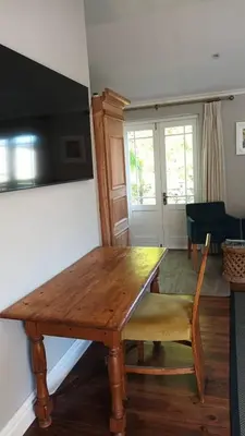 a wooden dining room table with a yellow chair and a table at Loft de L'Opera - Franschhoek in Franschhoek