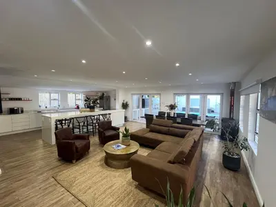 a living room with a couch and chairs and a kitchen at Riebeeck Villa - 5 min walk to Franschhoek Central in Franschhoek
