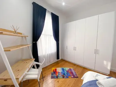 a bedroom with a desk and a window and a chair at Modern 8 Sleeper home in trendy Observatory in Cape Town