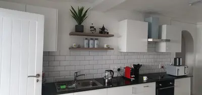 a kitchen with white cabinets and a sink at Modern 8 Sleeper home in trendy Observatory in Cape Town