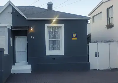 a blue house with a window and a white door at Modern 8 Sleeper home in trendy Observatory in Cape Town