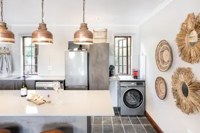 a kitchen with a refrigerator and a washing machine at Avemore Orchard Apartment - with full Backup power in Stellenbosch