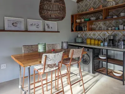 a kitchen with a wooden table and chairs at Tulbagh Mountain Bungalow in Wolseley
