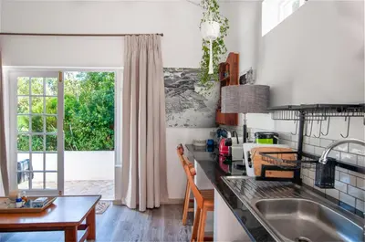 a kitchen with a sink and a table at The Earthy Inn in Greyton