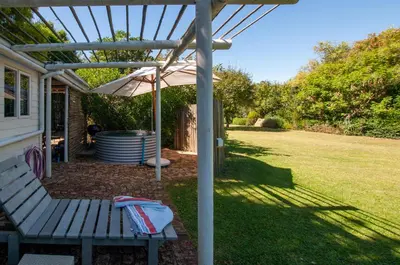 a picnic table with an umbrella in a yard at The Earthy Inn in Greyton