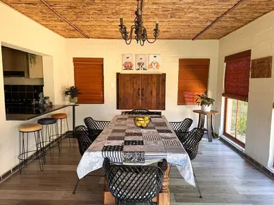 a dining room with a table and some chairs at Cottage K'Gari in Franschhoek