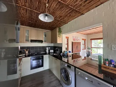 a large kitchen with a washer and dryer in it at Cottage K'Gari in Franschhoek