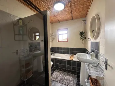 a bathroom with a shower and a sink and a tub at Cottage K'Gari in Franschhoek